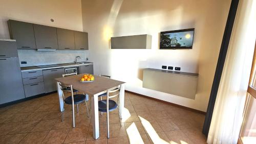 a kitchen with a table and chairs in a room at Residence Borgo Dei Limoni - Appartamenti con Garage in Gargnano