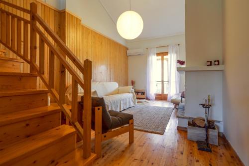 a living room with a staircase and a couch at LEA's HOME - Cozy Chalet with Mountain View in Vytina