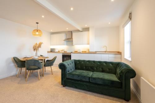 a living room with a green couch and a table at Apartment 4, King's Court in Scarborough