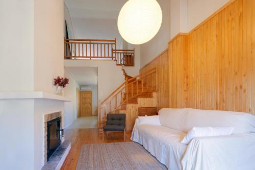a living room with a white couch and a fireplace at LEA's HOME - Cozy Chalet with Mountain View in Vytina