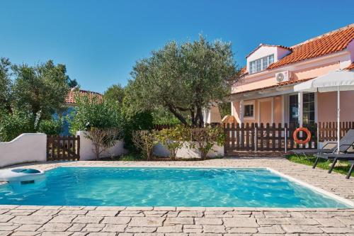 a swimming pool in a yard next to a house at Villa Cleo Periyali in Vasilikos