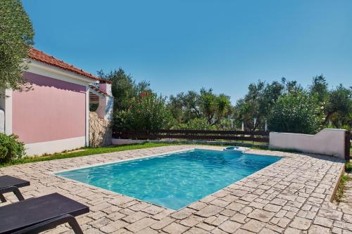 a small swimming pool in a yard with a patio at Villa Cleo Periyali in Vasilikos