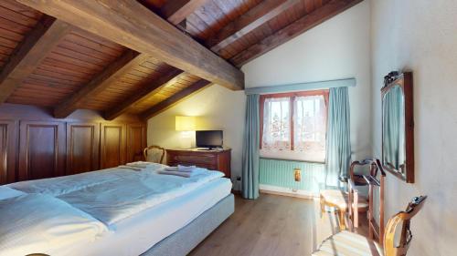 a bedroom with a bed and a desk and a window at Ste 10 in Celerina