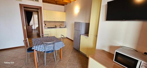 a kitchen with a table and chairs and a television at Residence Borgo Dei Limoni - Appartamenti con Garage in Gargnano