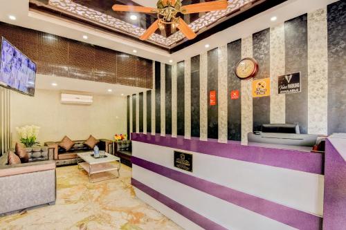 a lobby of a hotel with a clock on the wall at Capital O Good Luck Residency Hotel in Guwahati
