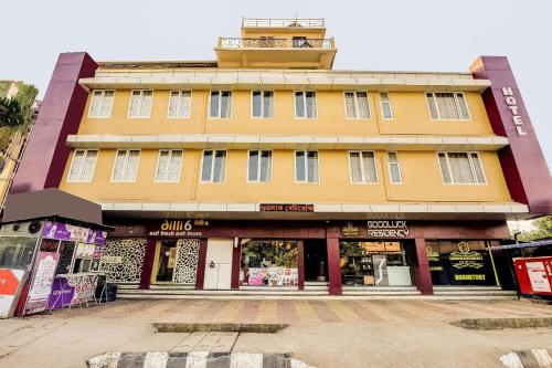een geel gebouw met een toren erop bij Capital O Good Luck Residency Hotel in Guwahati