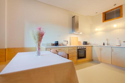 a kitchen with a table with a vase of flowers on it at LEA's HOME - Cozy Chalet with Mountain View in Vytina