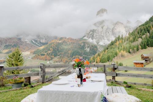 a table with a bottle of wine and flowers on it at Luxury Chalet Liosa - Ski in Ski out - Amazing view in Corvara in Badia