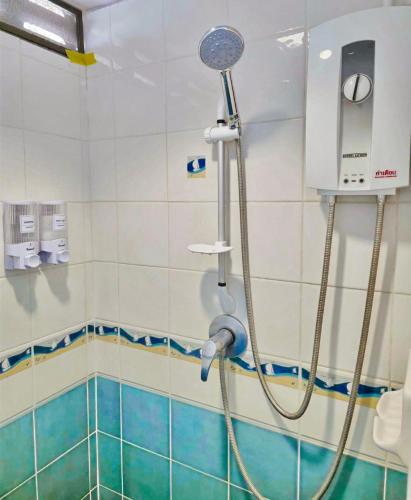 a shower in a bathroom with blue and white tiles at Lanta MP Place in Ko Lanta