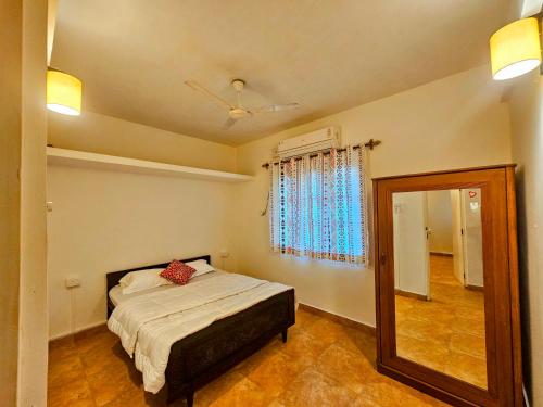 a bedroom with a bed and a mirror at 2BHK Modern Apartment in Colva