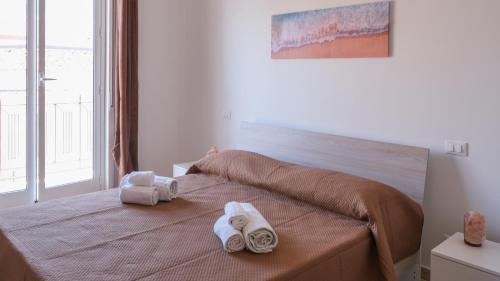 a bedroom with a bed with towels on it at Terrasini Downtown Terrace in Terrasini
