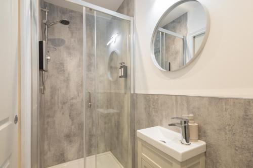 a bathroom with a shower and a sink and a mirror at Apartment 4, King's Court in Scarborough