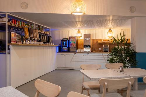 a restaurant with a table and chairs and a kitchen at The Originals Résidence Paris Sud Villejuif in Villejuif