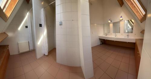 a large bathroom with two sinks and a mirror at La Ferme Saint Pierre de Glabais in Genappe
