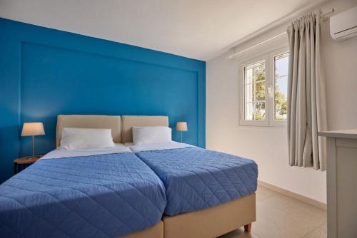 Un dormitorio azul con una cama con una pared azul. en Villa Artemis Periyali, en Vasilikos