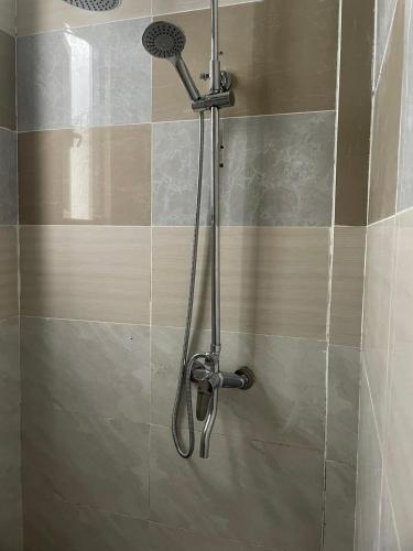a shower with a shower head in a bathroom at Yanaya Stay in Male City