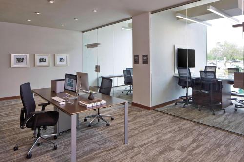 an office with a desk with a computer and chairs at AC Hotel by Marriott Des Moines East Village in Des Moines