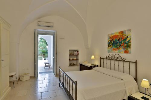1 dormitorio con 1 cama y pasillo con mesa en Salento - Casa Pietrastella, en Presicce
