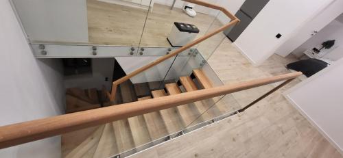 a wooden staircase with a glass railing in a house at Anita's Mansion in Gattendorf