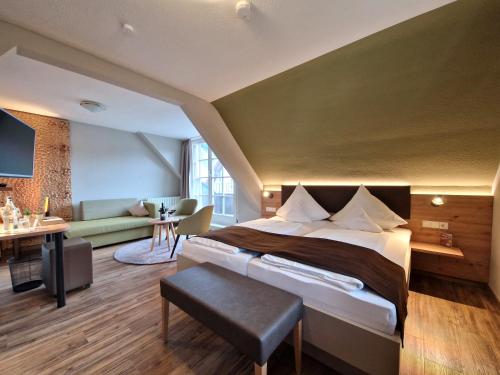 a hotel room with a large bed and a couch at Hotel-Gasthaus Goldener Engel in Glottertal