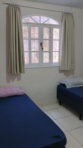 a room with two beds and a window at Casa Espaçosa a 200m da praia in Florianópolis