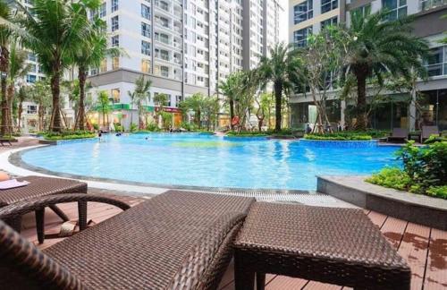 a large swimming pool in a building with tables and chairs at Hana homestay 1 phòng ngủ tại Vinhome Central Park in Ho Chi Minh City