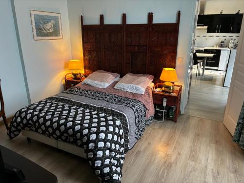 Cet appartement comprend une chambre avec un lit et deux lampes ainsi qu'une cuisine. dans l'établissement Appartement, à Granville