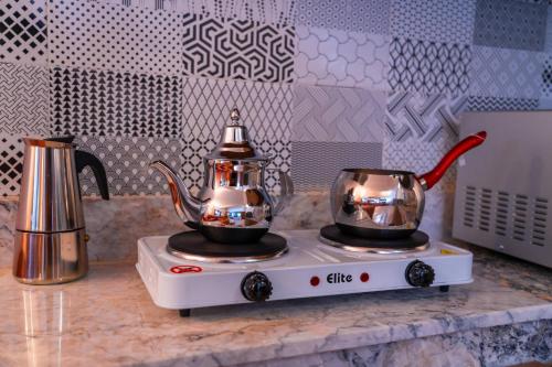 two teapots on a stove on a kitchen counter at Appart-Hôtel BEL ANFA in Casablanca