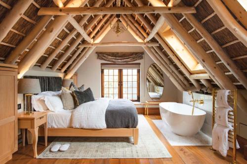 a bedroom with a large bed and a bath tub at The Hazendal Hotel and Homestead in Stellenbosch