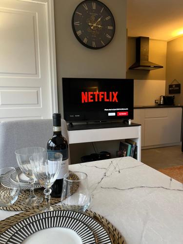 a table with a bottle of wine and a clock on the wall at Favolosa Suite con Terrazzo in Vicenza