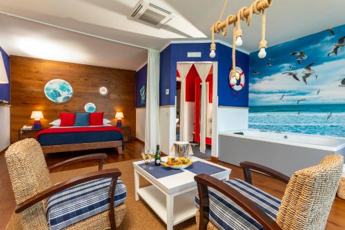 a bedroom with a bed and a living room with a table at Hotel Kalura in Cefalù