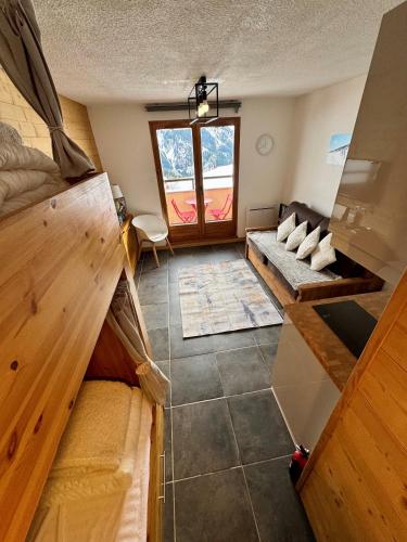 un salon avec un canapé et une fenêtre dans l'établissement Le lodge by Lilou, à Manigod