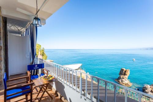 a balcony with a table and chairs overlooking the ocean at Hotel Kalura in Cefalù
