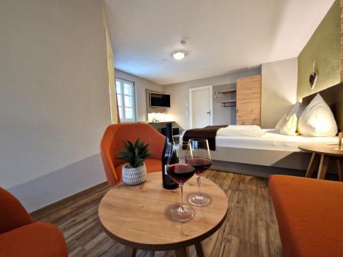 a hotel room with two glasses of wine on a table at Hotel-Gasthaus Goldener Engel in Glottertal