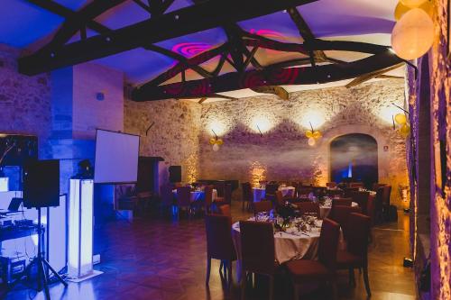 une salle à manger avec des tables, des chaises et un éclairage violet dans l'établissement Superbe Château et son Gîte de Château de l'Estang à Saint Emilion, à Saint-Genès-de-Castillon