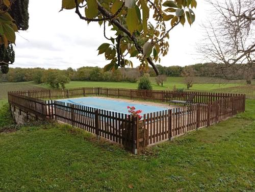 une clôture en bois avec une piscine sur gazon dans l'établissement Superbe Château et son Gîte de Château de l'Estang à Saint Emilion, à Saint-Genès-de-Castillon