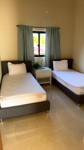 two beds sitting in a room with a window at Casa Vista Mar in Río San Juan