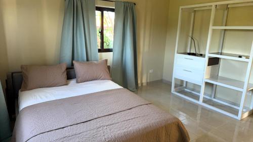 a bedroom with a bed and a dresser and a window at Casa Vista Mar in Río San Juan