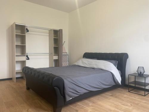 un lit dans une chambre blanche avec un cadre de lit noir dans l'établissement Victor Hugo 2, à Roubaix