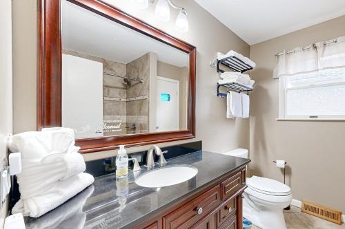a bathroom with a sink and a mirror and a toilet at Teal Haven in Ocean Pines