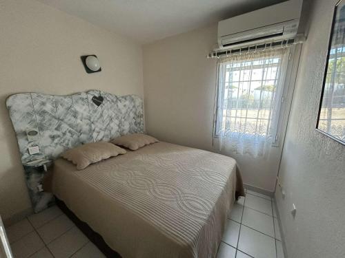 une petite chambre avec un lit et une fenêtre dans l'établissement Port Camargue, T2 climatisé, terrasse, parking, animaux admis - FR-1-250-219, au Grau-du-Roi