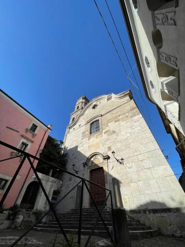 a tall stone building with a door and stairs at Casa Portella in Venafro