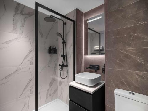 a bathroom with a shower and a sink and a toilet at Radisson RED London Gatwick Airport in Crawley