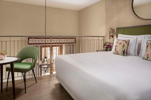 a bedroom with a large white bed and a table at Tivoli Palazzo Gaddi Firenze Hotel in Florence