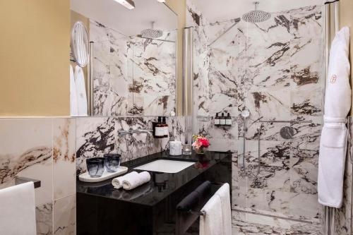 a bathroom with a sink and a shower at Tivoli Palazzo Gaddi Firenze Hotel in Florence