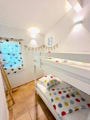 une chambre avec un lit superposé dans une pièce dans l'établissement La Camargue Appartment mit Pool, à Aigues-Mortes