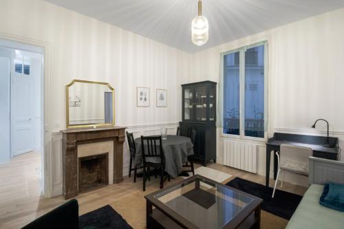 - un salon avec une table et un miroir dans l'établissement Au cœur des Batignolles -Bail mobilité - 1 chambre, à Paris