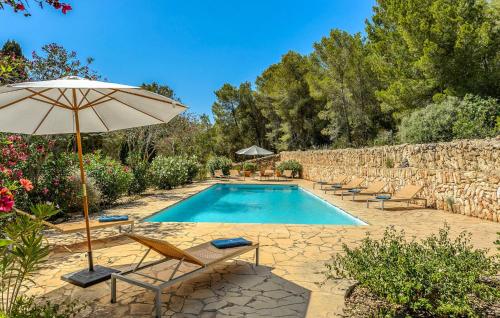 una piscina con sillas y sombrilla en Villa Can Felix, en Santa Gertrudis