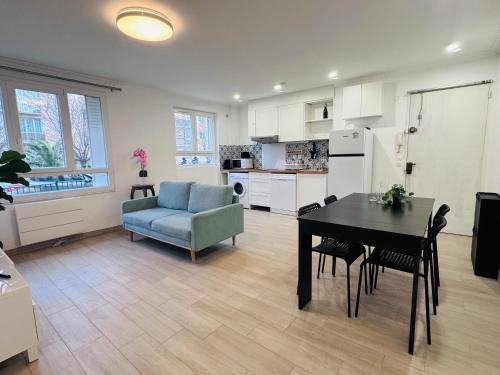 Il dispose d'une cuisine et d'un salon avec une table et une chaise bleue. dans l'établissement Grand F4 Rueil proche Paris et RER A Calme et Confort au Coeur de la Ville, à Rueil-Malmaison