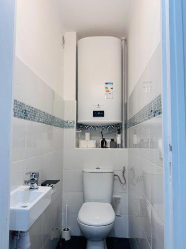 une salle de bain blanche avec des toilettes et un lavabo dans l'établissement Grand F4 Rueil proche Paris et RER A Calme et Confort au Coeur de la Ville, à Rueil-Malmaison